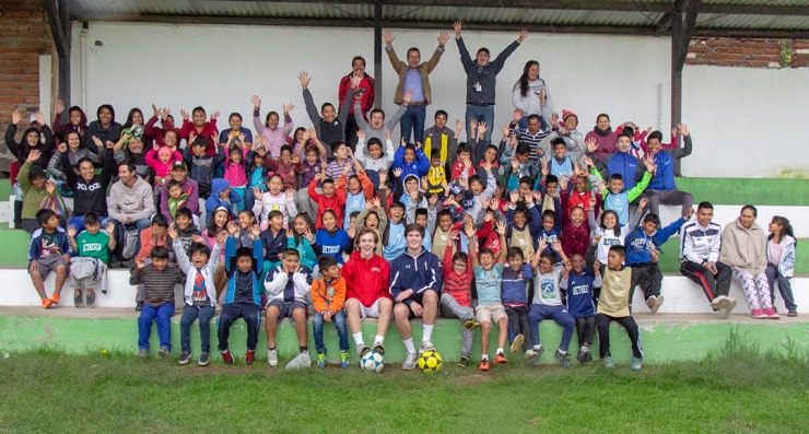 High school soccer players and volunteers with children they are helping in Equador