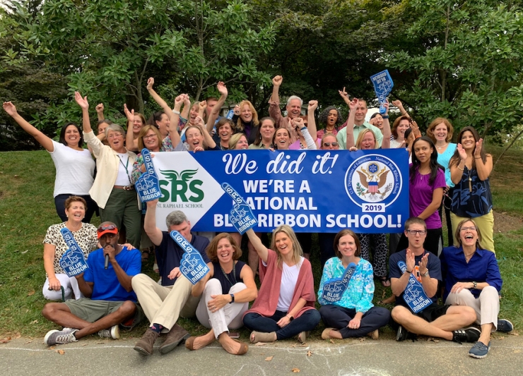 Staff members cheering, with large banner saying, "We did it! We're a National Blue Ribbon School!"